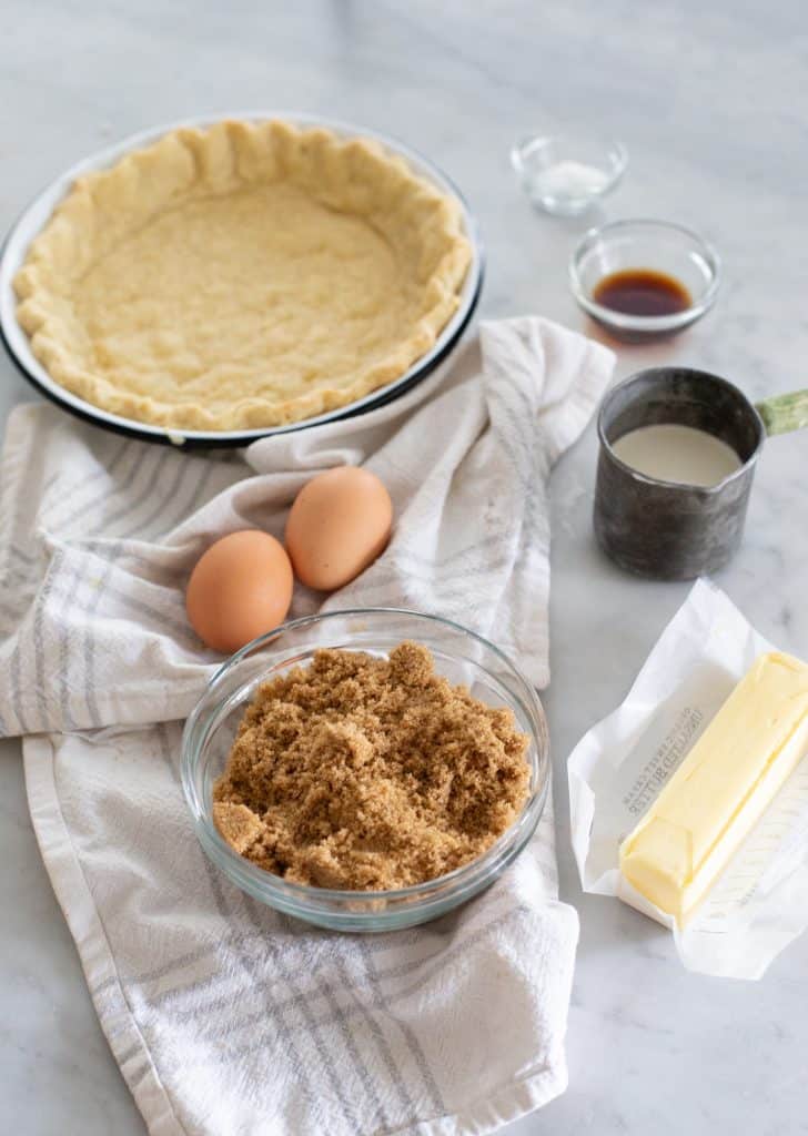 Brown Sugar Pie ingredients including crust, brown sugar, eggs, heavy cream, vanilla extract, and butter.